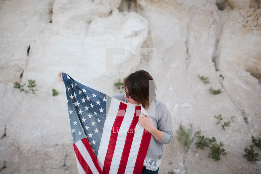  a woman walking carrying an American flag 