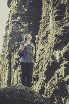 woman standing alone on a rock outdoors 