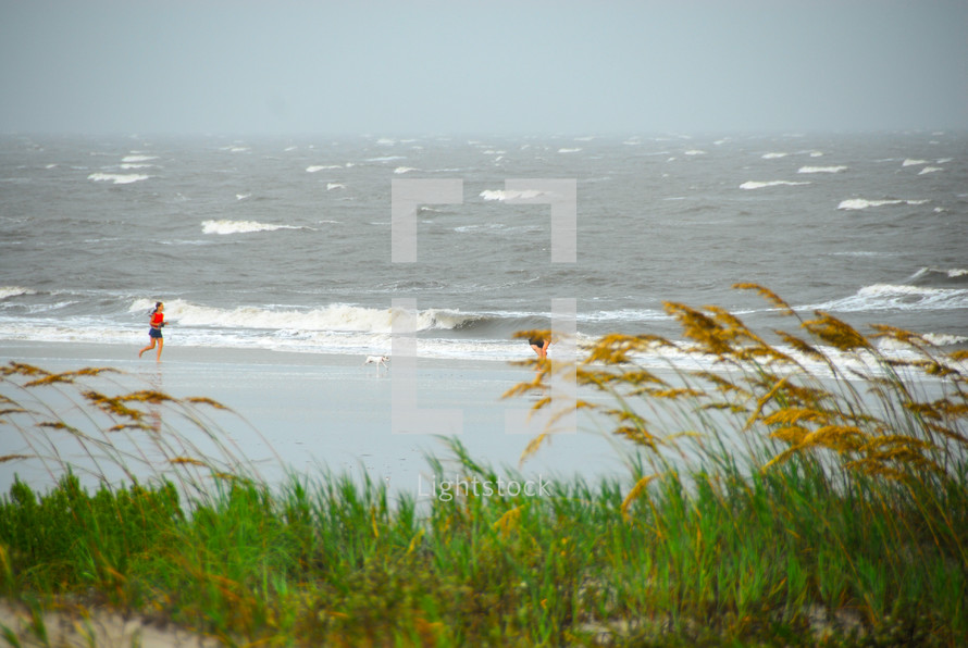 Runners exercising on Litchfield beach, Pawley Island, South Carolina on a stormy day