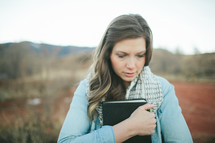 woman holding a Bible close to her chest 
