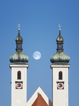 spire towers and full moon 