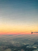 view of a wing of a plane through a wet window 