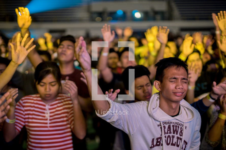 crowds with hands raised in praise to God 