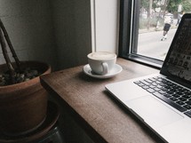 laptop computer and coffee cup on a wooden desk 