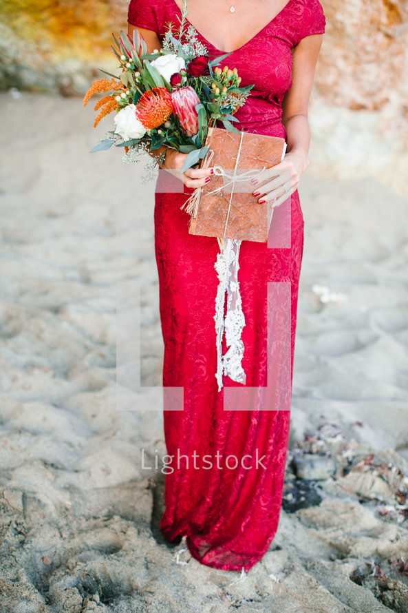 woman in a red dress holding a bouquet of flowers 