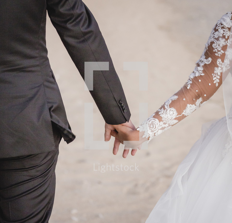bride and groom holding hands 