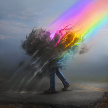 A rainbow loses its color in a dark cloud around a person