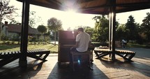 man playing a piano outdoors 
