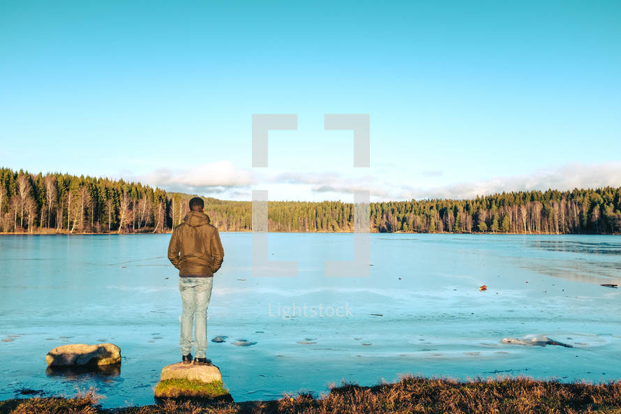 a man standing on a lake shore