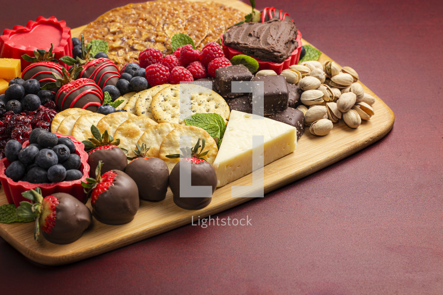 Chocolate Covered Strawberries and Cheese Sweet Charcuterie Board on a Red Table