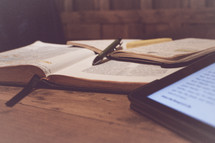 opened Bible and tablet on a desk 