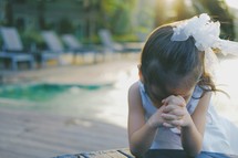 a praying child with head bowed 