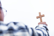 a man holding up a wooden cross