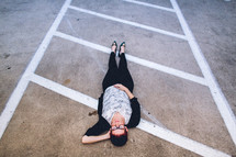woman lying in a parking lot 