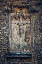 crucifix on the side of an old church 