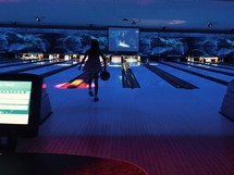 a girl bowling at a bowling alley 