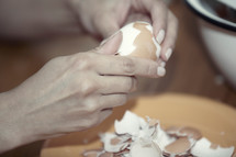 a woman peeling a hardboiled egg 