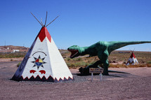 tepee and dinosaur statue 