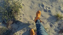 Boots Walking In The Desert Leaving Footprints