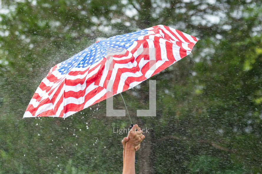 Holding an American flag umbrella in the rain