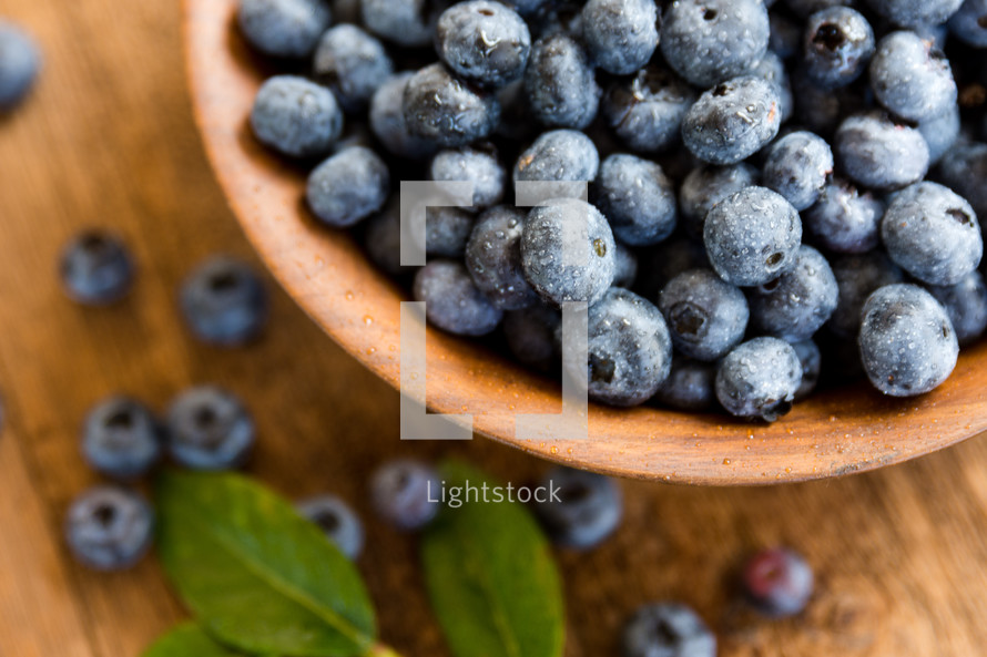 a close up of fresh berries with leaves in a bowl
