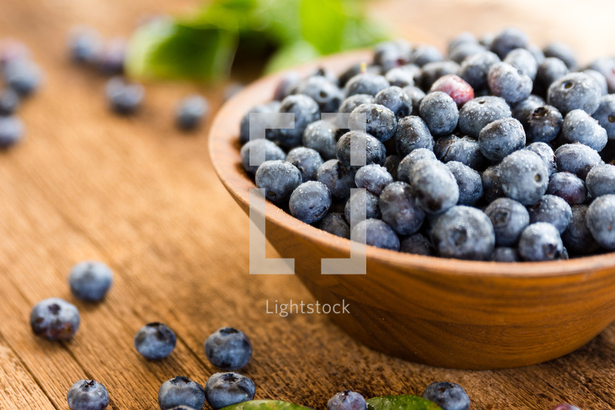 a close up of fresh berries with leaves in a bowl