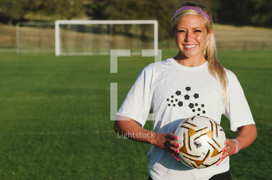 teen girl holding a soccer ball 