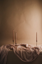candlesticks and mauve linen fabric 