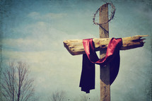 crown of thorns and a red shroud on a cross