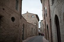 A narrow lane through old stone buildings.