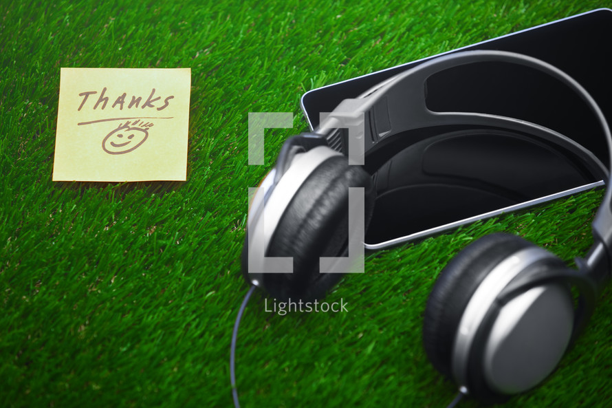 headphones, tablet, and thanks note 
