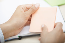 woman holding a pad of sticky notes 