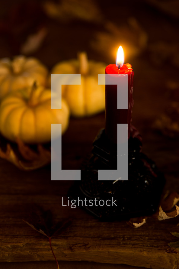 a candle with fall pumpkins