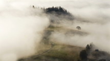 Wave of misty clouds covering rural country landscape time-lapse

