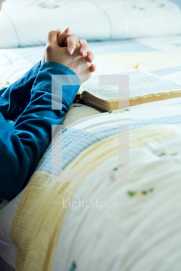 praying beside the bed with a bible