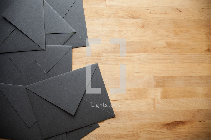 black envelopes on a wood floor 