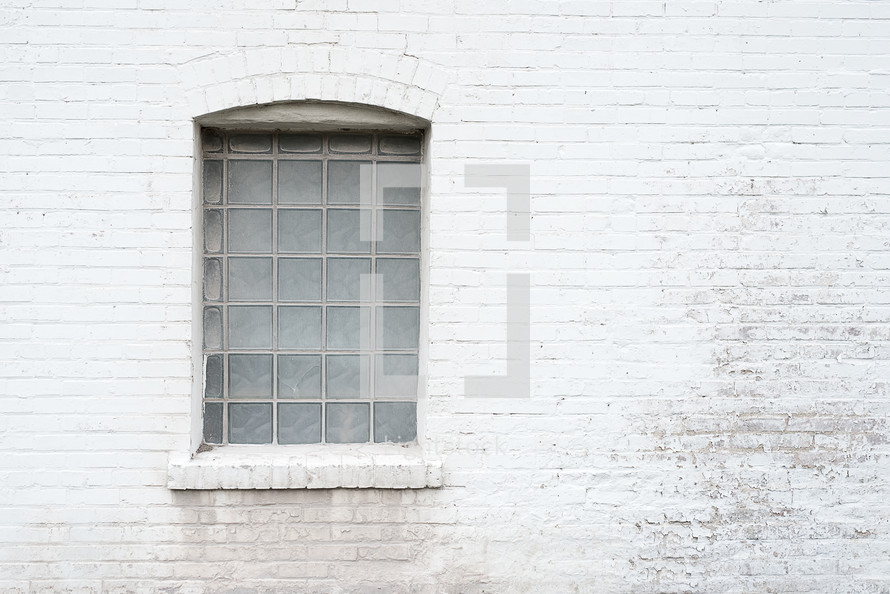 window on a grungy white brick wall 