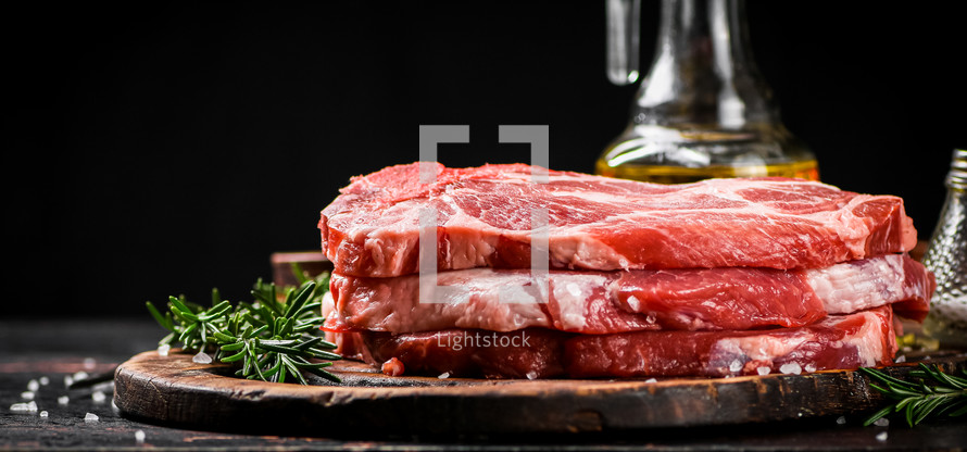 Raw pork steak on a stone board. On a black background. High quality photo