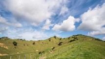 Clouds moving over green countryside landscape in New Zealand wild nature Time lapse
