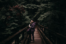 a woman on a bridge resting during a hike 