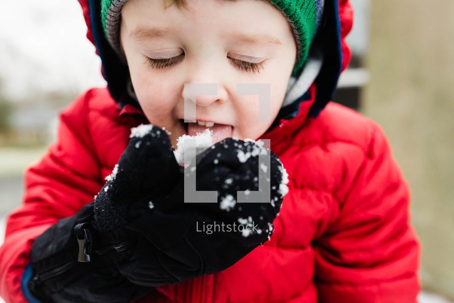 boy child eating snow 
