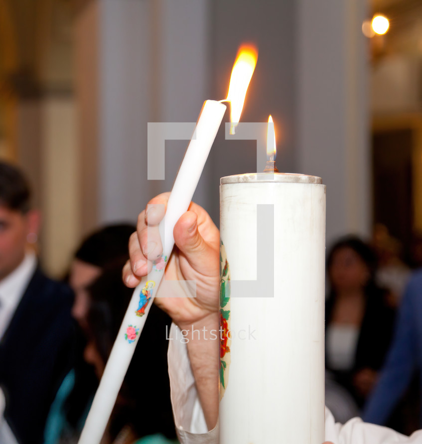 Priest lighting a candle during the sacrament of marriage 