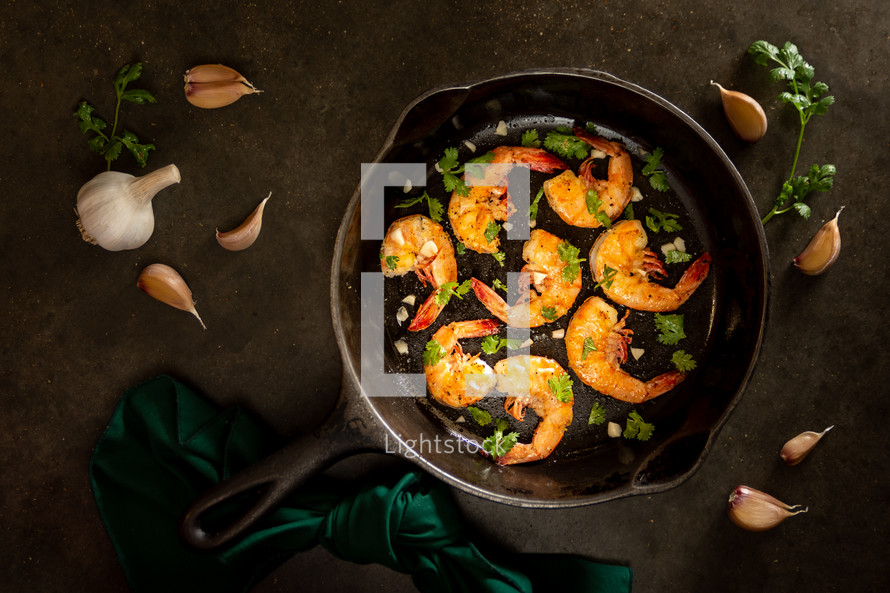 A cast iron skillet with grilled shrimp