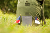 a military backpack with america and christain flags and a Bible