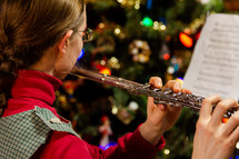A girl playing the flute at christmas time