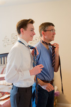 father and son putting on ties 