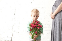 little boy holding a bouquet of flowers for his mother