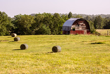 A red barn in a hay field