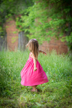 child spinning in a fuchsia dress 