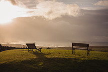 benches on a hilltop overlooking the ocean 